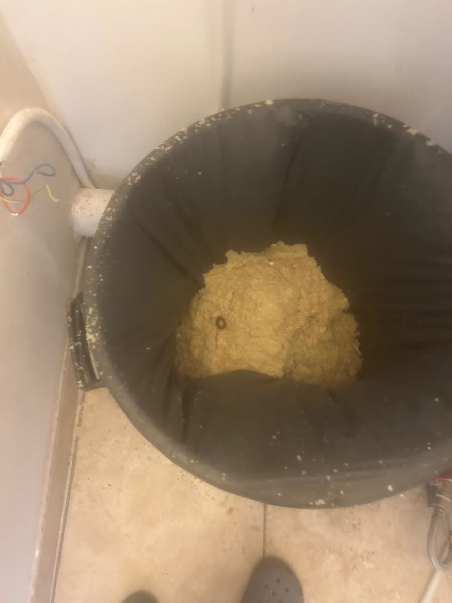 Bloc de calcaire retiré d'un chauffe-eau, dans un seau